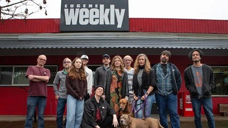 staff of the Eugene Weekly pose in front of the building