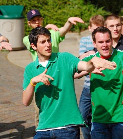 Alex Horwitch and other students dance while singing outdoors