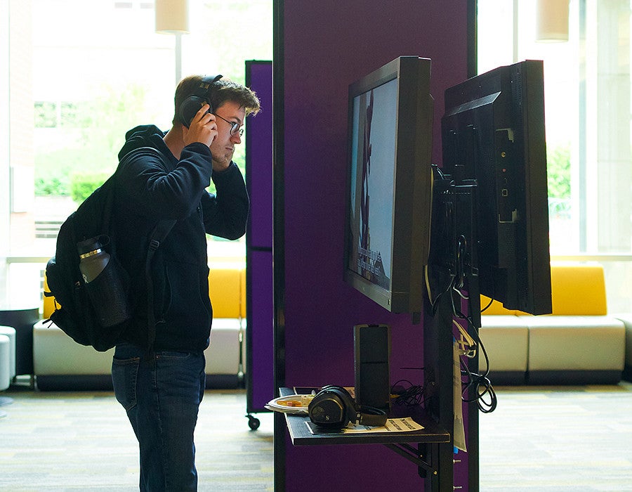 a student explores the Big Easy Blues video at the reception in Allen Hall