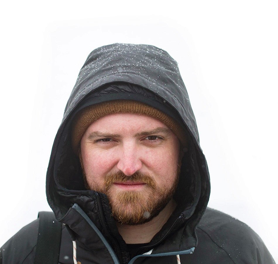 portrait of Jeff Dean wearing a hooded jacket in the snow