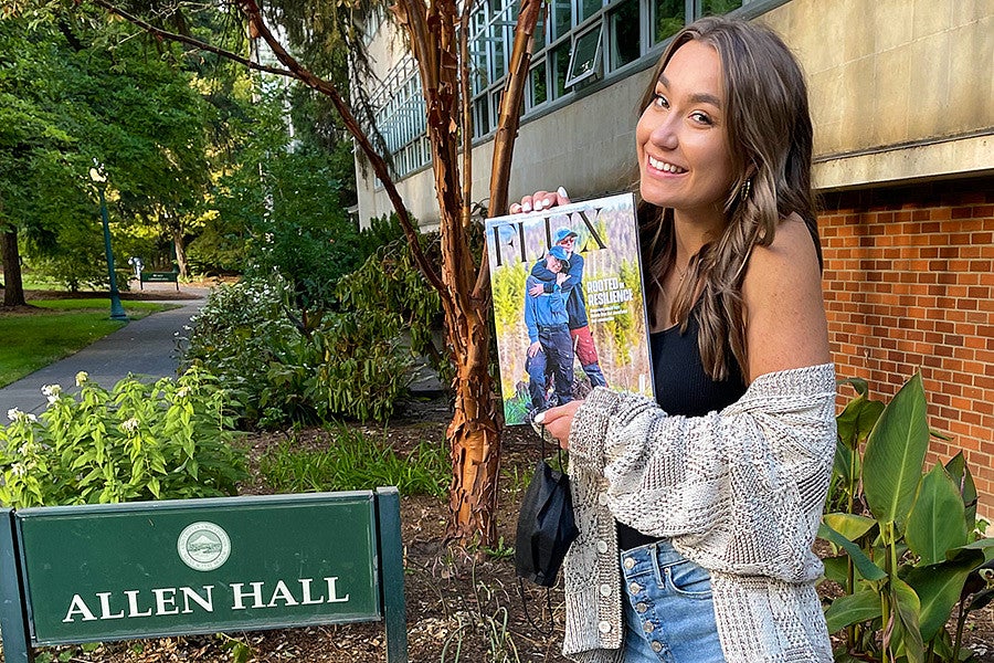 A student holds a copy of Flux magazine outside of Allen Hall