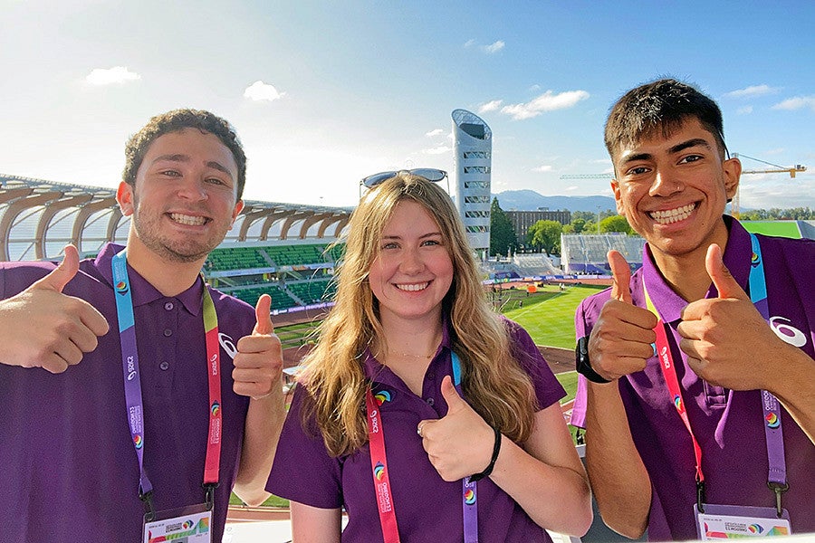 Three SOJC Track Bureau students give thumbs up from Hayward Field