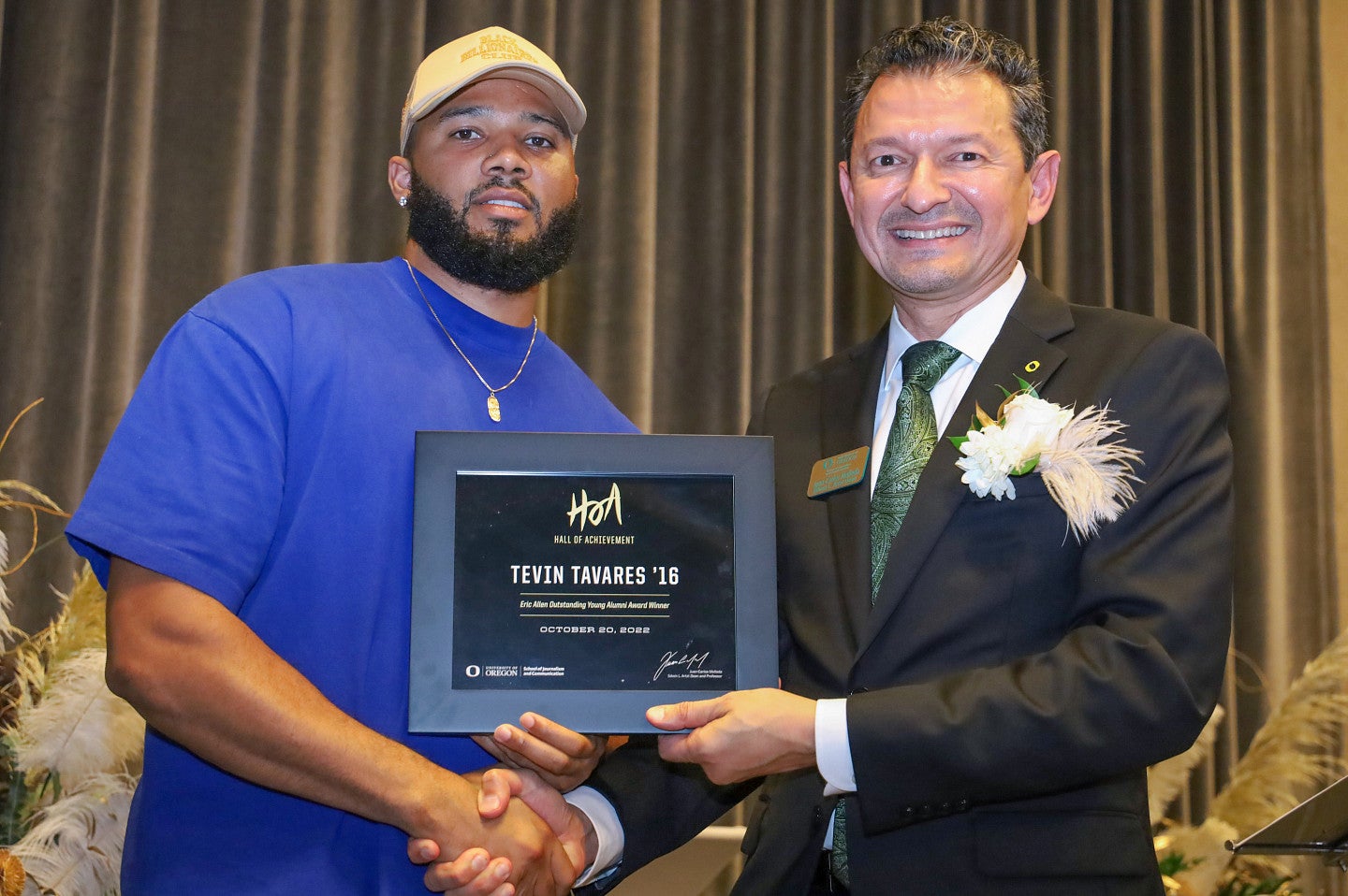 Tevin Tavares receives his certificate for the Eric Allen Outstanding Young Alum Award from Dean Juan-Carlos Molleda