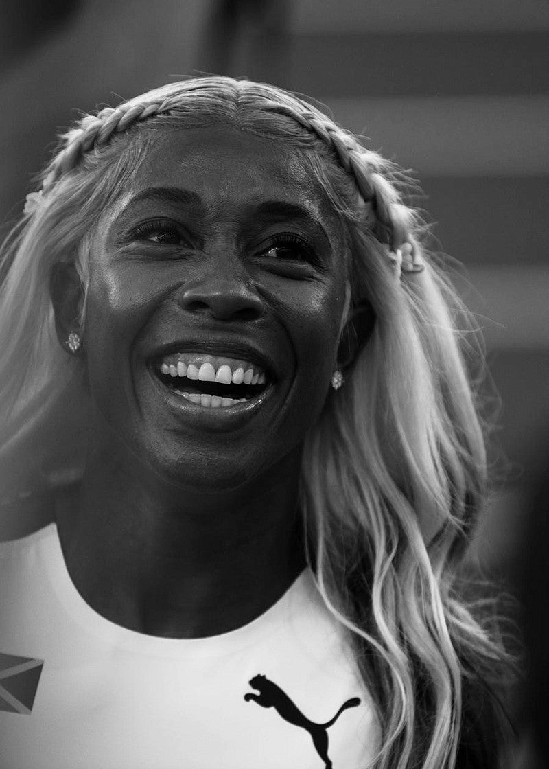 black and white image of Jamaican athlete Shelly-Ann Fraser-Pryce smiling. Photo by Chloe Montague.
