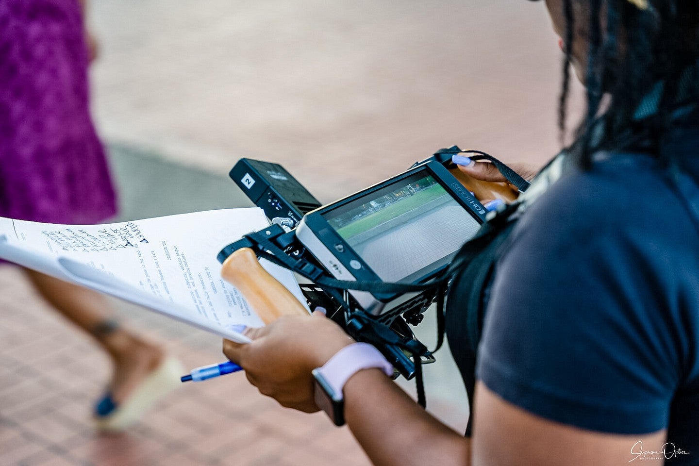 looking over the shoulder of a person holding a script and a handheld film monitor