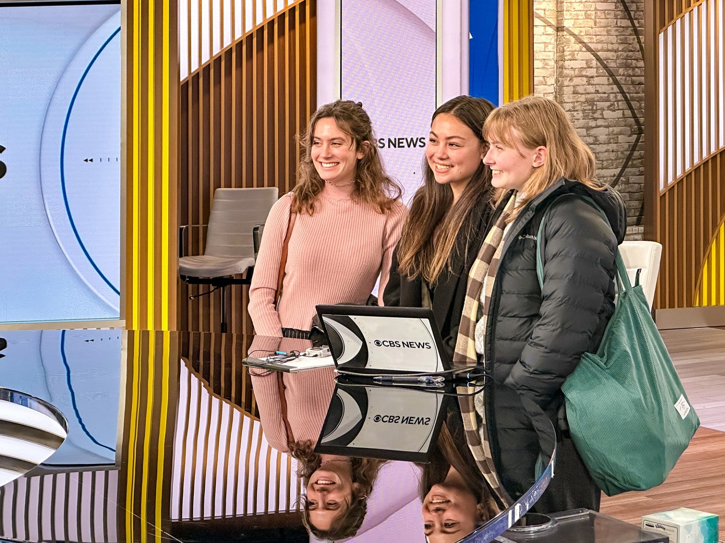 Sydney Seymour and two other students pose at the news desk of CBS News