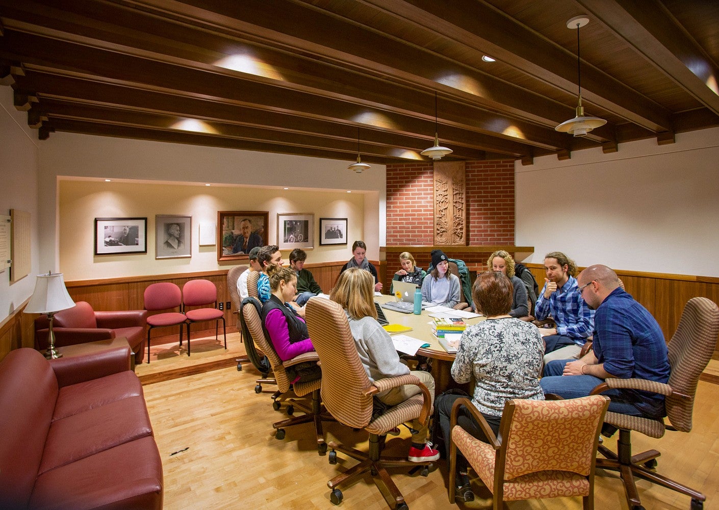 students sit around a conference table in the Allen Room