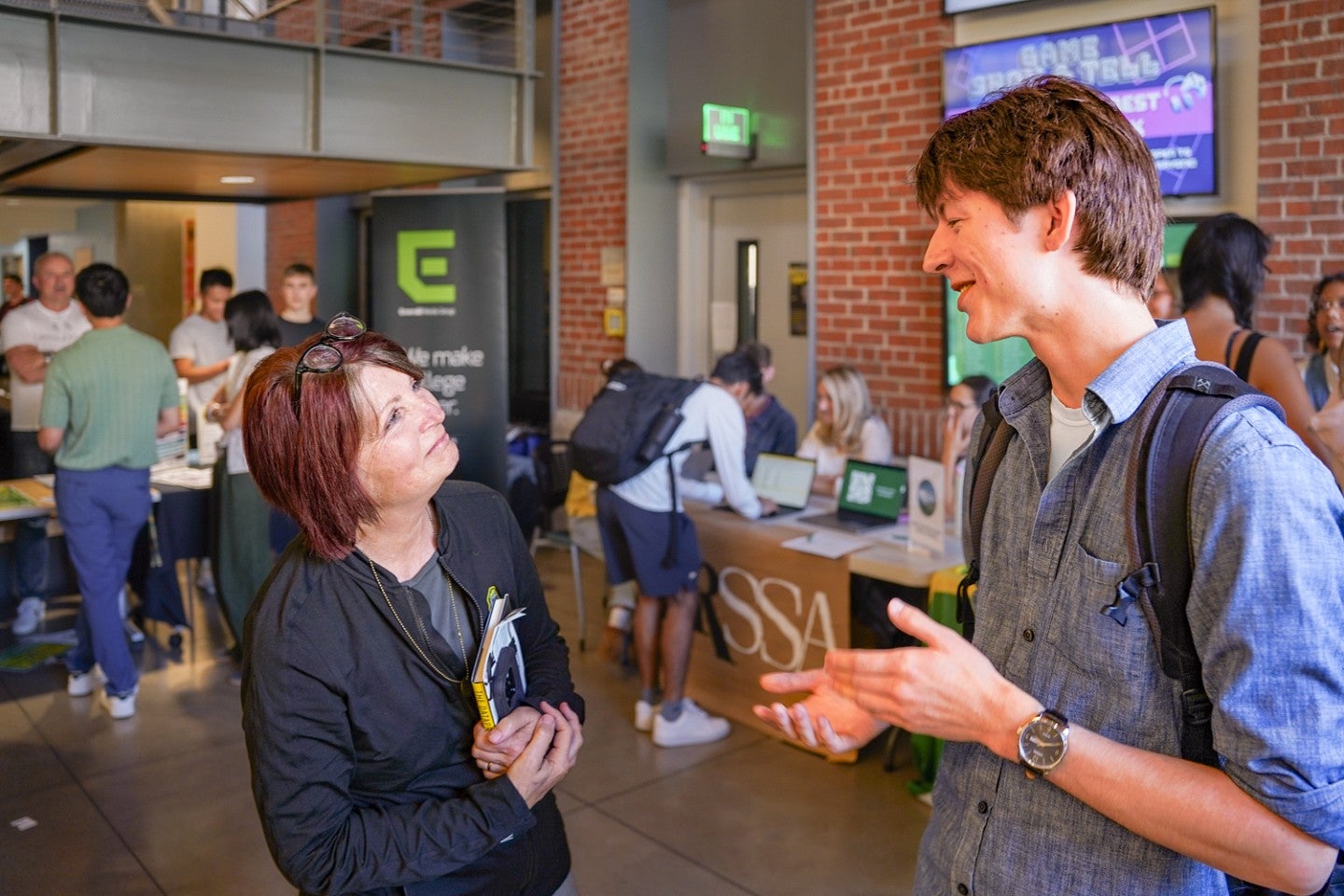 Deb Morrison chats with a student in the atrium of Allen Hall during a back-to-school event
