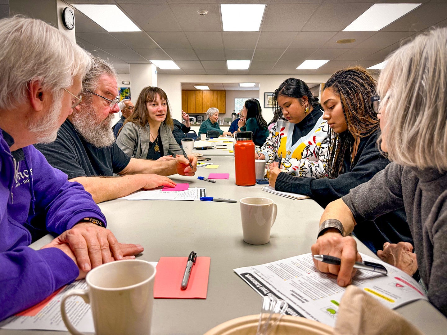 students and community members sit around a conference table