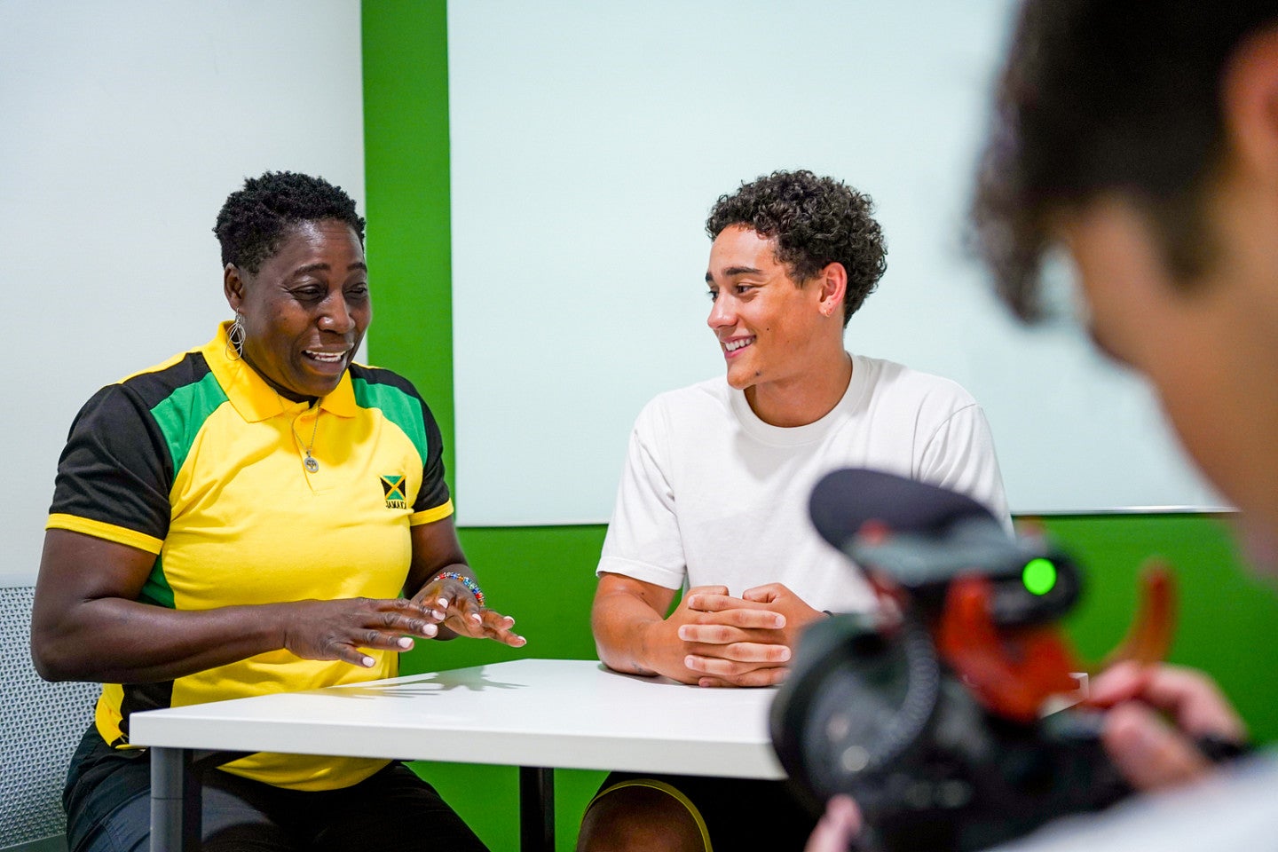 A student interviews a Jamaican athlete
