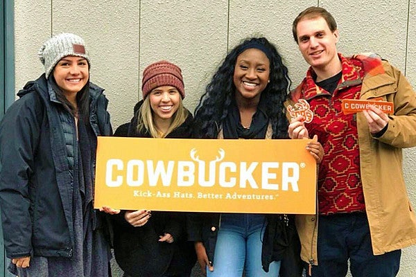 Allen Hall public relations students holding Cowbucker sign Allen Hall public relations students holding Cowbucker sign