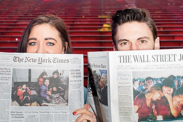 Two students eyes above two newspapers