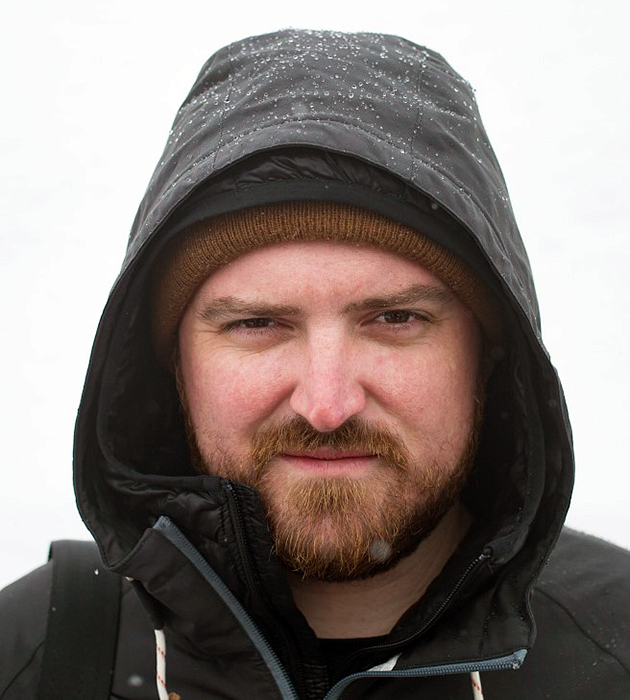 Jeff Dean wears a hooded black coat with a background of snow