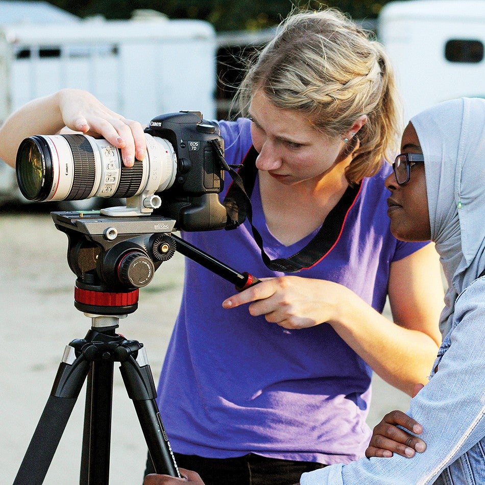 Two female students setting up a camera on a tripod
