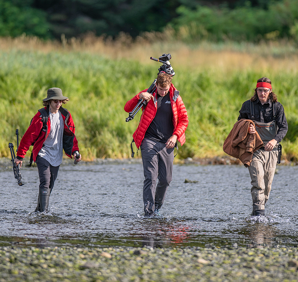 Students wading a river in Alaska