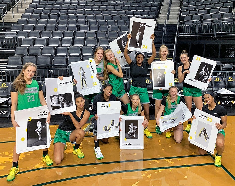 Members of the UO Women's Basketball team pose with posters created by Allen Hall Advertising