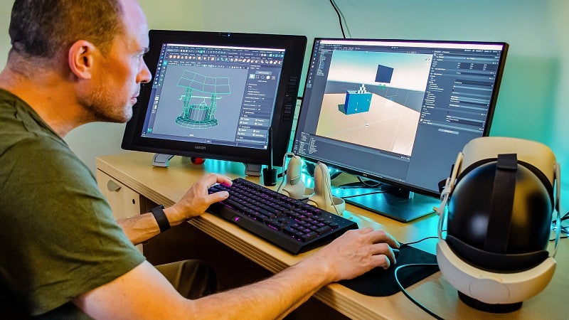 A person doing immersive design on two computer monitors 