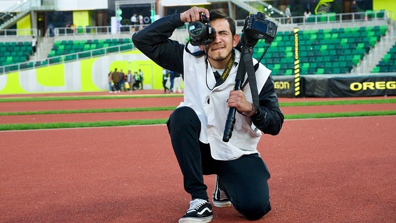 A student takes photos at Hayward Field