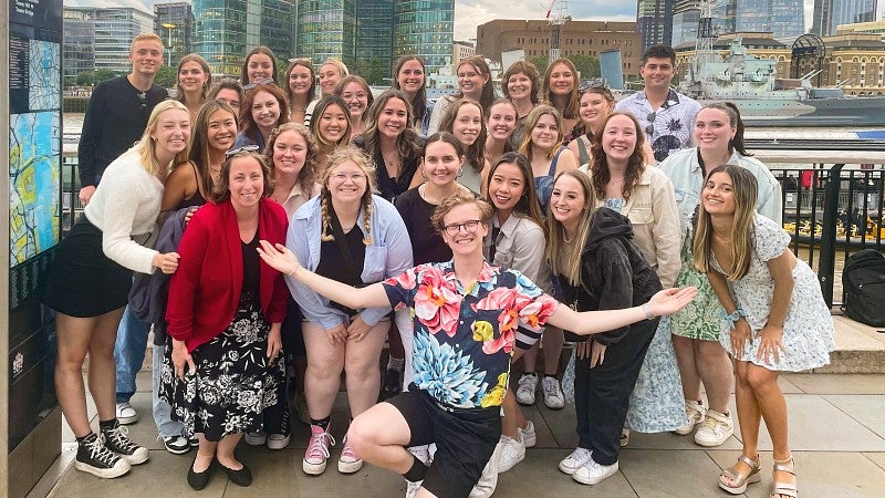 large group of students posing in front of London's skyline