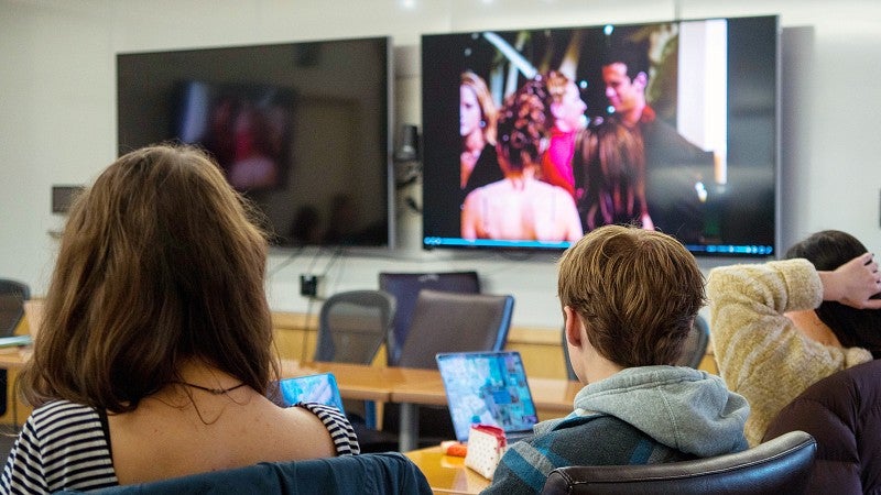 students watch a TV screen showing clips from The Bachelor