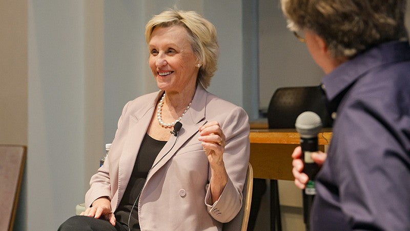 Tina Brown smiles while seated during her lecture