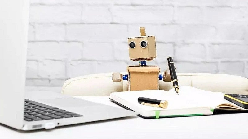 stock photo of a cardboard robot taking notes