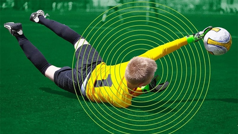 digital composite of a youth soccer goalie diving for a ball with illustrated rings around his head