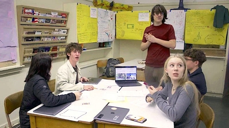 a group of high school students around a table