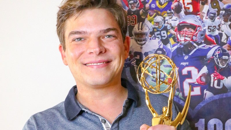 portrait of Sam Katzman holding an Emmy award