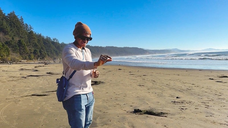 a person wearing AR glasses stands on an Oregon beach 