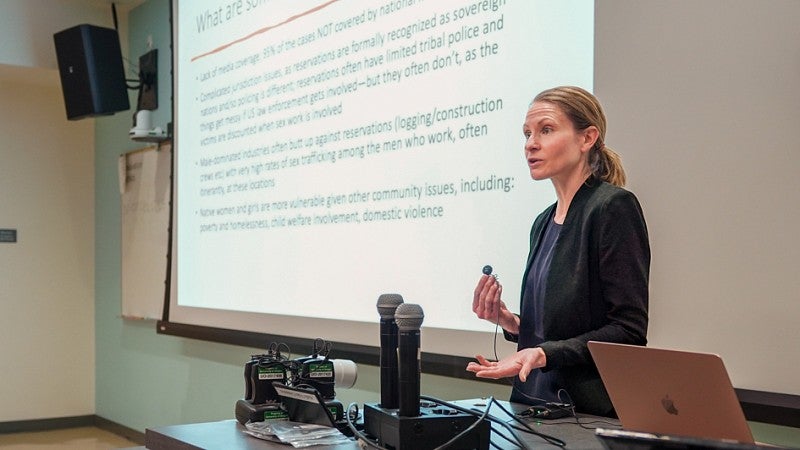 Whitney Phillips presents in front of a classroom digital screen