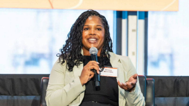 Ariana Donaville speaks into a microphone while participating in a panel discussion