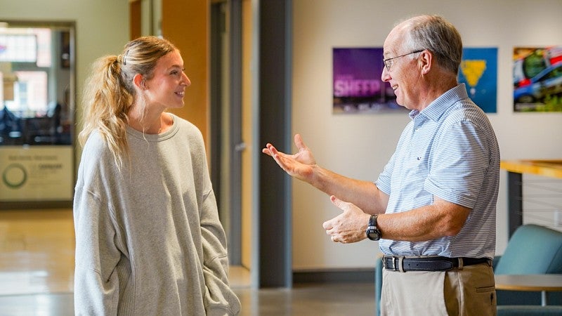 Ella Pinn and Charlie Butler chat in the atrium of Allen Hall