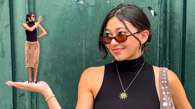 Kaia Mikulka looks at her outstretched hand where a smaller, AI-generated version of herself stands and waves at her