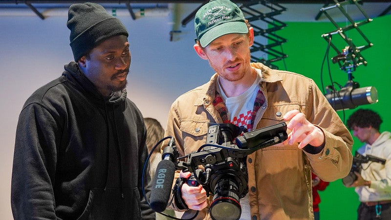 two students in the Multimedia Storytelling Master's program at the University of Oregon School of Journalism and Communication work on a multimedia journalism project in the studio