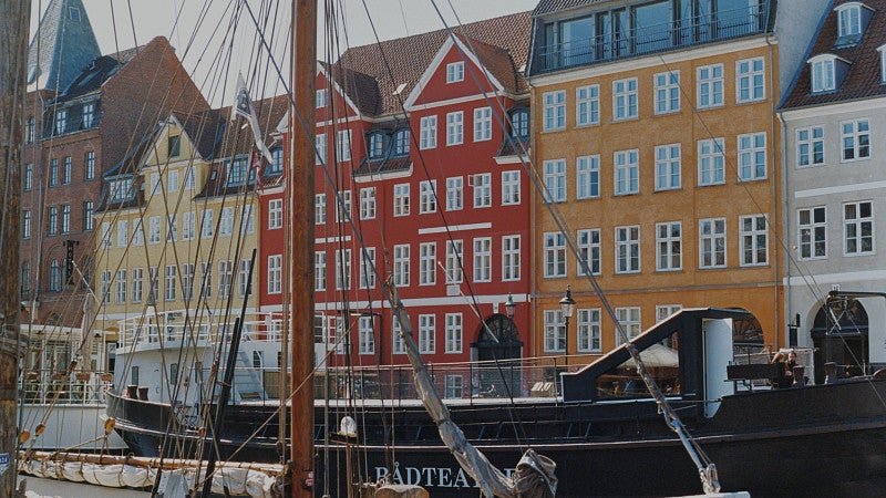 colorful row houses in Copenhagen with sail boats in the foreground