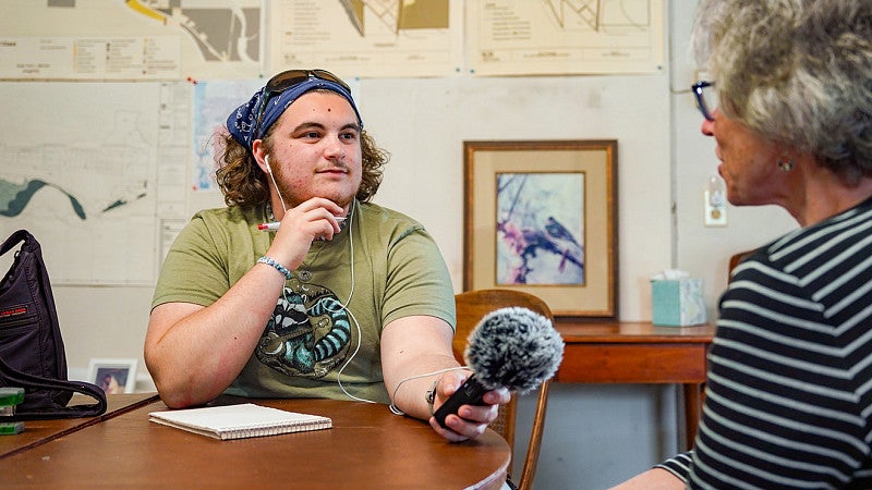 SOJC journalism student Kai Schrosk records an interview with an Oakridge resident