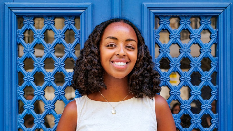 portrait of Hana Mazur in front of vibrant blue doors
