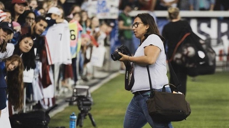 Photojournalist takes photo of crowd during a baseball game.