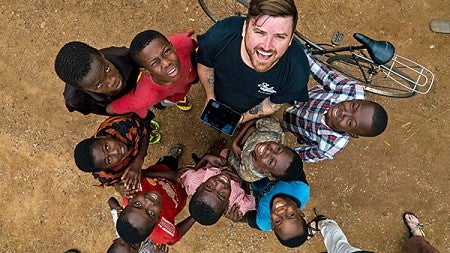 An overhead drone shot of a student with young children in Africa