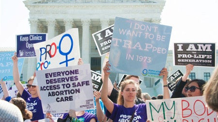 demonstrators hold signs at a pro-choice rally