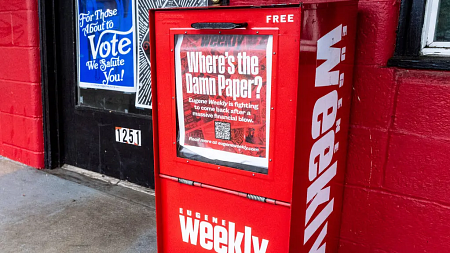 A red Eugene Weekly newspaper box with a sign that says "Where's the Damn Paper?"