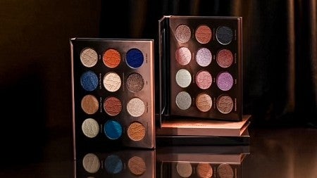 product shot of two eyeshadow palettes by Shades by Shan in dark dramatic lighting
