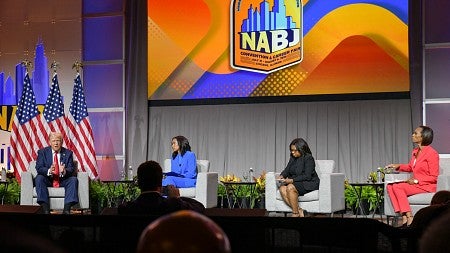 Donald Trump sits on stage with three journalists at the 2024 NABJ convention