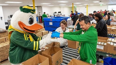 Juan-Carlos Molleda and The Duck work together to package food at a food bank