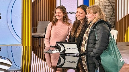 Sydney Seymour and two other students pose at the news desk of CBS News