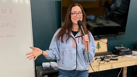 Eva Camacho presents in front of a white board
