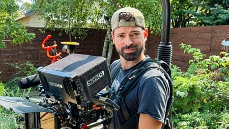 Kyle LaMontagne poses while wearing a large stabilized camera rig