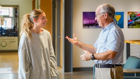Ella Pinn and Charlie Butler chat in the atrium of Allen Hall
