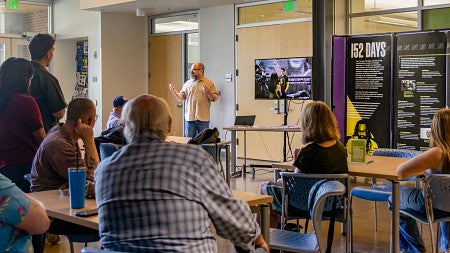 David Ewald presents to a group of people seated in the foreground